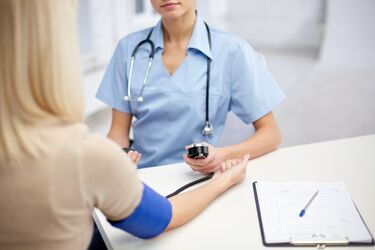 Ärztin misst einer Patientin den Blutdruck